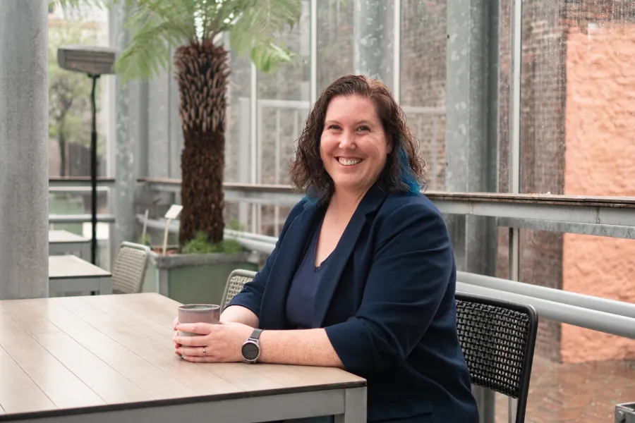 Blue Ninja Founder Louisa Stewart sitting on a table drinking coffee
