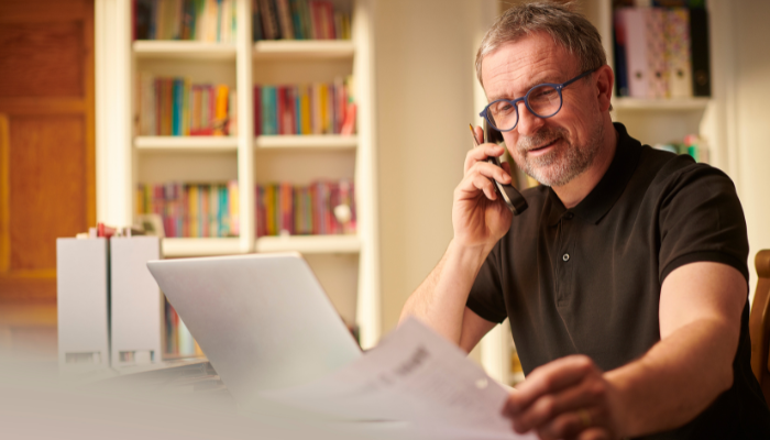 Business owner talking on phone and reading paperwork